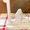 A farmhouse white distressed wooden cutout of the nativity scene under the Christmas star in the creche. The Distressed White Nativity cutout is a silhouette style nativity and available at Quilted Cabin Home Decor.