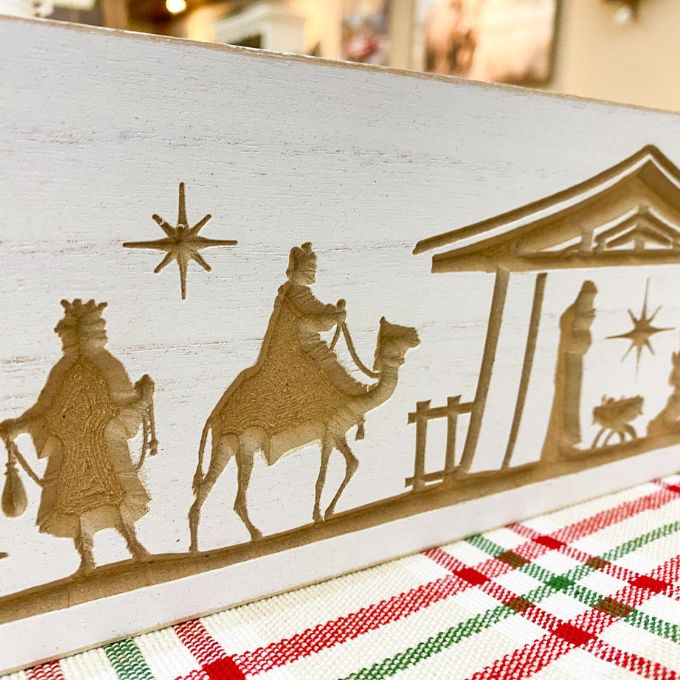 Wooden nativity scene cutout with three wise men on a white background. Distressed White Carved Nativity Block Sign available at Quilted Cabin Home Decor.