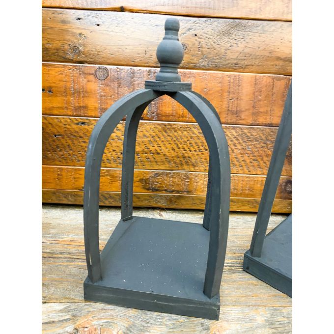 Decorative black wooden lantern with a wooden background. Black Curved Top Lantern - Two Sizes available at Quilted Cabin Home Decor.