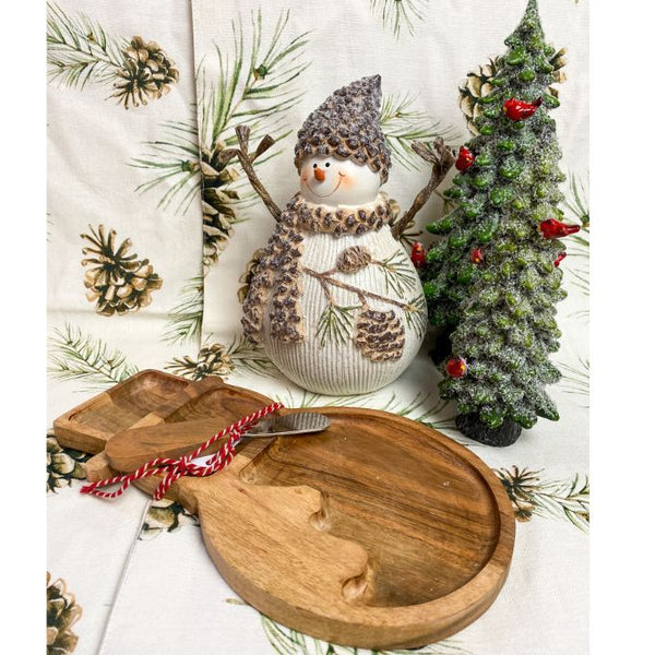 Wooden cheese board shaped like a snowman comes with a wooden handled knife. Shown here with a resin snowman and evergreen tree. Available at Quilted Cabin Home Decor.