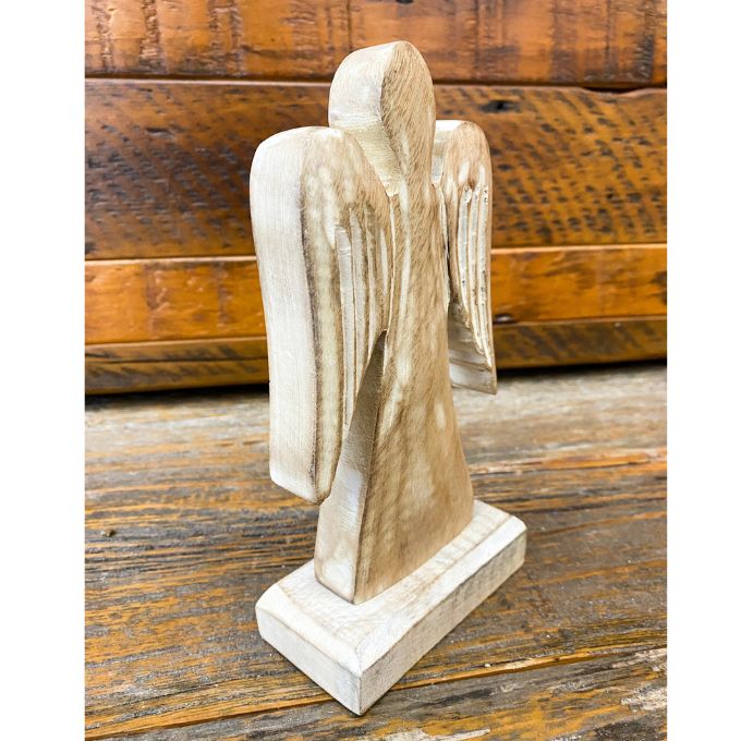 Wooden angel figurine on a rustic wooden surface. Distressed White Wooden Angel available at Quilted Cabin Home Decor.