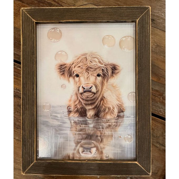 Framed artwork of a Highland cow with water and bubbles on a wooden background. Bubble Bath Babe available at Quilted Cabin Home Decor.