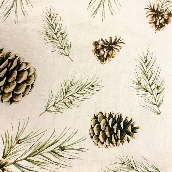 Woodland pines table runner is a neutral coloured runner with pine cones and boughs on it. Available at Quilted Cabin Home Decor.