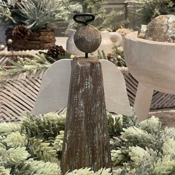 Decorative angel figure with rustic finish on a bed of greenery. Driftwood Angel Figurine available at Quilted Cabin Home Decor.