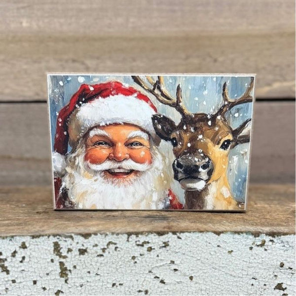 Art Block with Santa Claus and a reindeer on a wooden surface. Santa And Reindeer Art Block is available at Quilted Cabin Home Decor.