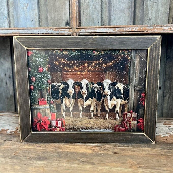 Framed picture of three holstein cows in a barn with Christmas decorations. Moo Christmas Framed Print available at Quilted Cabin Home Decor.