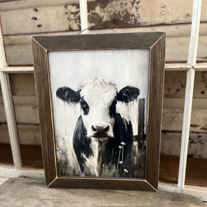Framed painting of a cow's face on a rustic wooden background. Cow Portrait framed art available at Quilted Cabin Home Decor.