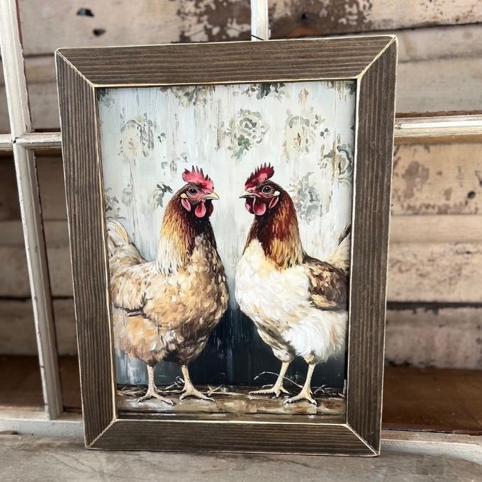 Framed artwork of two chickens on a rustic wooden surface. Chicken Talk Framed Wall Art available at Quilted Cabin Home Decor.