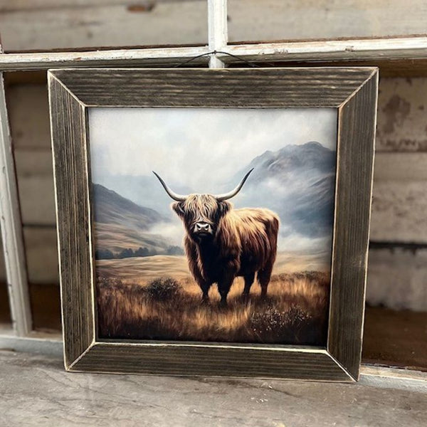 Framed picture of a Highland cow in a field with mountains in the background. Fall Highland framed Art is available at Quilted Cabin Home Decor.