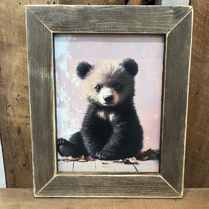 Framed picture of a bear cub on a wooden surface. Baby Bear Framed Print available at Quilted Cabin Home Decor.