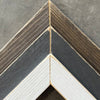 Close-up of a wooden frame with a chevron pattern on a gray background