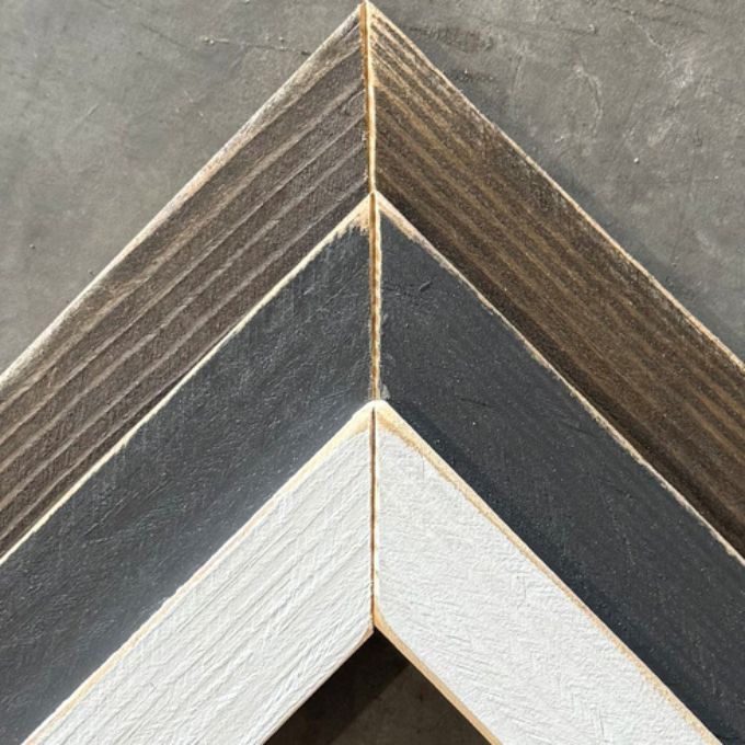 Close-up of a wooden frame with a chevron pattern on a gray background