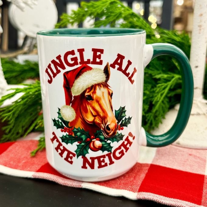 Jingle all the neigh Christmas mug available at Quilted Cabin Home decor. It has a green handle and green interior and  horse in a santa cap on each side 