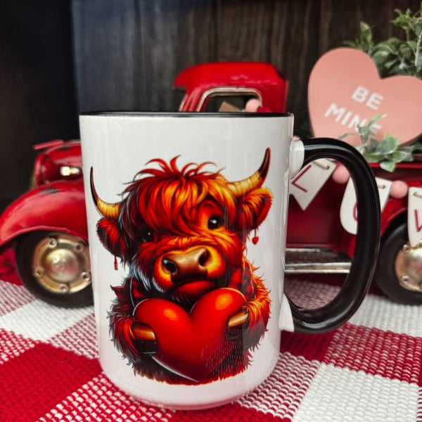 Baby Highland Cow Holding a Heart Mug available at Quilted Cabin Home Decor.