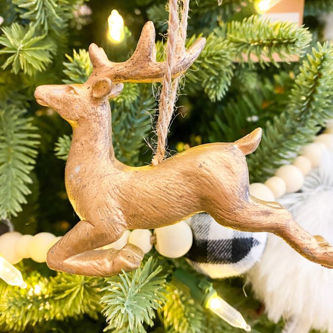 A Gold flying deer ornament that looks like it is jumping. Available at Quilted Cabin Home Decor.