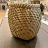 Woven -look basket on a wooden surface with a blurred background. Rattan Look Resin Vase available at Quilted Cabin Home Decor.