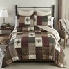 Patchwork quilt set on a bed in a bedroom setting. Pine Panels King Quilt Set available at Quilted Cabin Home Decor.