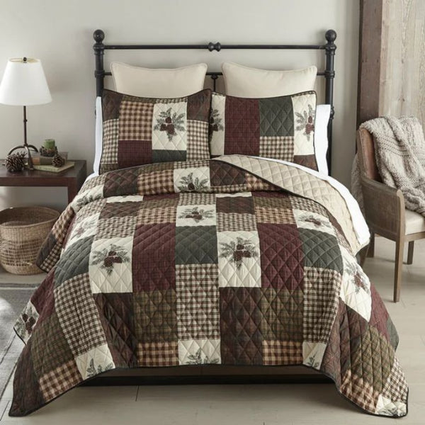 Patchwork quilt set on a bed in a bedroom setting. Pine Panels King Quilt Set available at Quilted Cabin Home Decor.