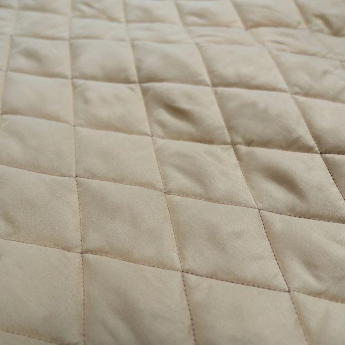 Close-up of beige quilted fabric with diamond pattern. Pine Panels King Quilt Set available at Quilted Cabin Home Decor.