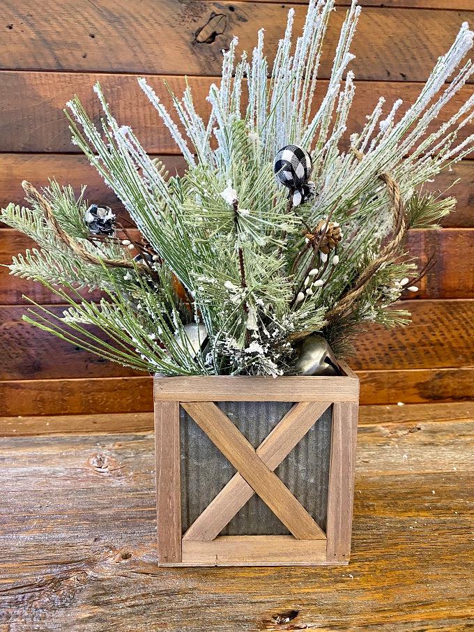  Wood trimmed galvanized corrugated metal boxes in two sizes are filled with floral. The boxes have an wood strapping on the outside in the shape of an X and all of the edges are faced with wood. 