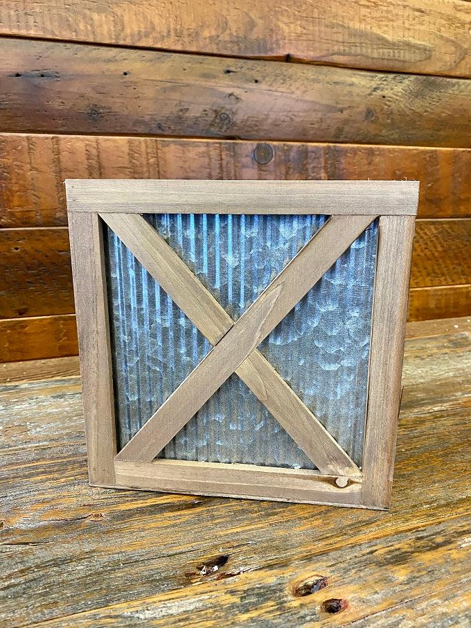  Wood trimmed galvanized corrugated metal boxes in two sizes are filled with floral. The boxes have an wood strapping on the outside in the shape of an X and all of the edges are faced with wood. 