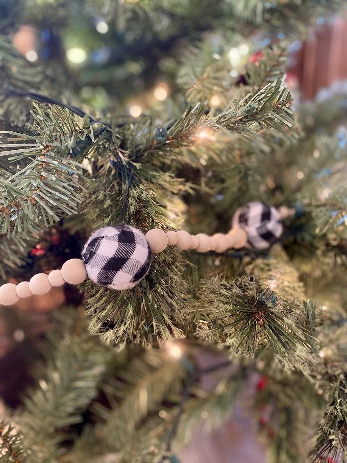 This Plain and Natural Beaded Garland is a string of natural coloured wooden beads separated by a larger black and white check or red and black check bead. Pictured is the black and white check bead.