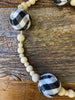 This Plain and Natural Beaded Garland is a string of natural coloured wooden beads separated by a larger black and white check or red and black check bead. Pictured is the black and white check bead.