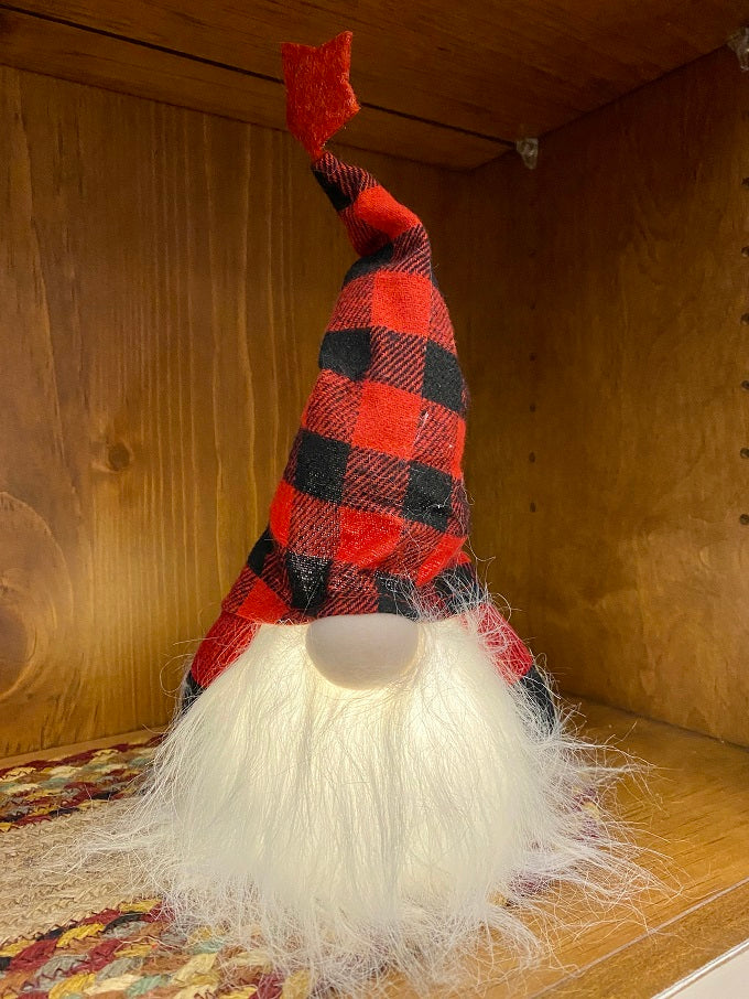 The Red and Black LED Gnome has a fuzzy whisy beard with a a red and black plaid hat with a red star on the top. The body of the gnome lights with an LED light. 