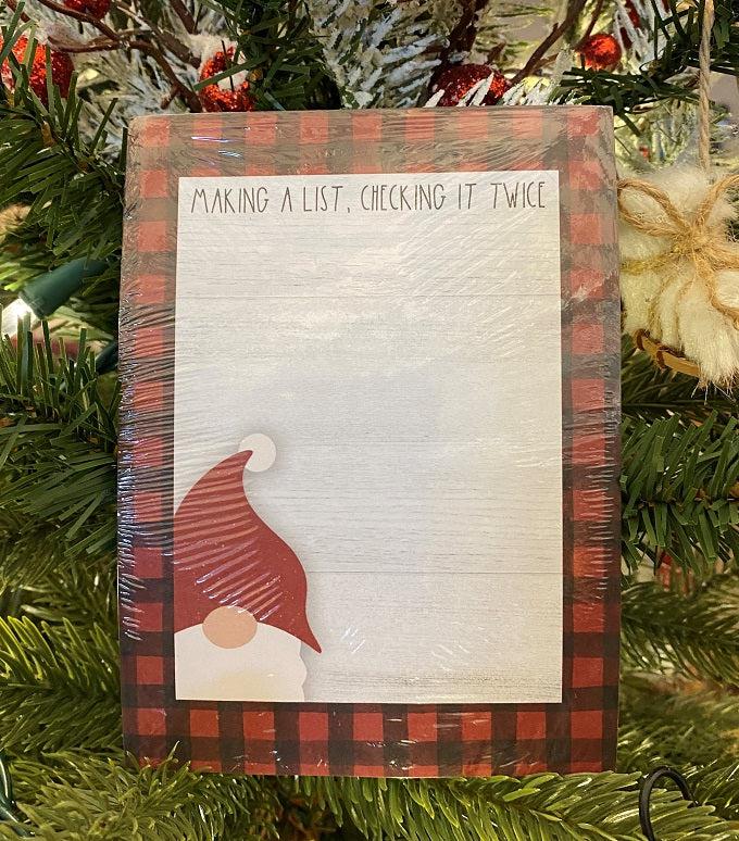  A farmhouse style notepad edged with red and black checked buffalo plaid. This notepad has a santa gnome on it that says "Making a List, checking it twice." 