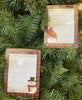 Pictured are two Farmhouse Christmas style notepads edged with red and black checked buffalo plaid. One notepad has a snowman in the corner that says  "It's so damn cold I just farted snowflakes" and the second notepad has a Santa gnome on it that says "Making a List, checking it twice." 