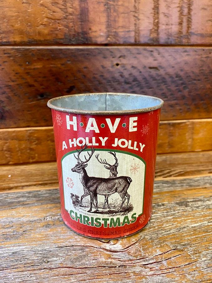 The vintage christmas metal can says Have a holly jolly christmas and has a pair of rendeer on the front. 