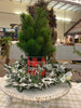 The red and black buffalo plaid vintage christmas metal can that says Good Tidings of Great Joy is shown with a balsam tree and the flocked Eucalyptus wreath.