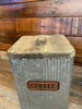Picture showing the wooden lid of a galvanized canister.