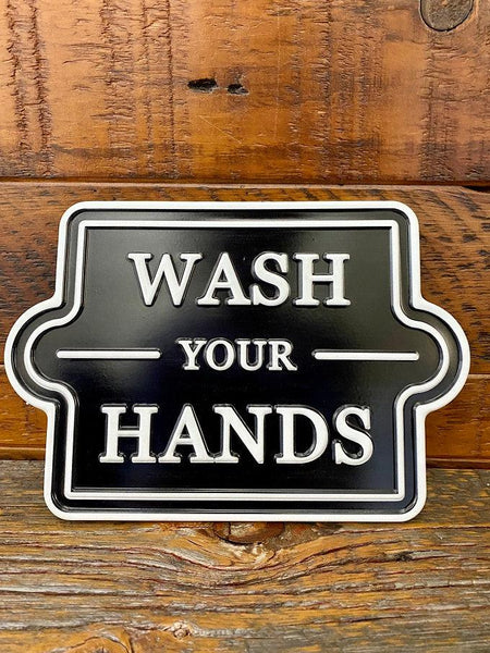 A black metal sign that is square but has curved sides. It says Wash your Hands in white. 