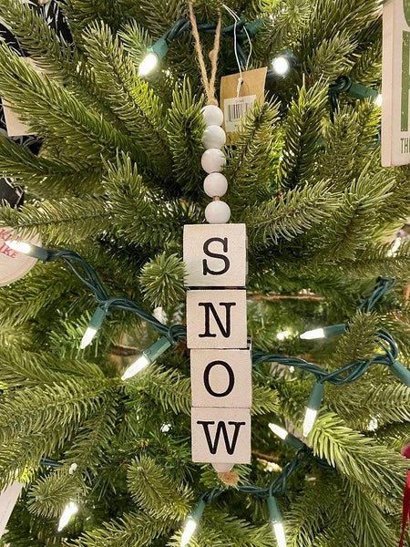  A Snow Cube Ornament with the letters of the word SNOW on each individual cube.The other three sides of the cube are painted in black and white plaid. The cubes are moveable so you can see the different sides. There is five white beads at the top of the cube stack hung on a jute rope hanger.