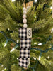  A Snow Cube Ornament with the letters of the word SNOW on each individual cube.The other three sides of the cube are painted in black and white plaid. The cubes are moveable so you can see the different sides. There is five white beads at the top of the cube stack hung on a jute rope hanger.