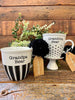 The Grandma Bear mug is white with black hearts in rows on the bottom half and the Grandpa Bear mug has black and white stripes along the bottom half of the mug. It is printed on both sides. 