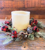 A candle ring from the Country holiday buffalo plaid collection. It is full with red and black buffalo plaid balls in two sizes, silver bells, greenery and pine cones.