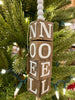 The Beaded Cube Ornament with the word Noel. The natural coloured cubes are printed with a single letter on all four sides and are moveable. Five white beads are at the top and one at the bottom of the ornament. 