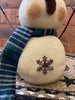 The Green plaid scarf snowman is a twostack snowman and has a black hat with green plaid trim and matching scarf. There  is a jingle bell trim on his hat and one metal snowlake on his bottom stack. The has two twiggy arms. 