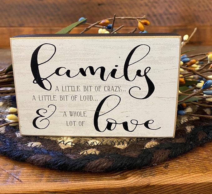 The Family Mini block sign that says: Famly a little bit of crazy, a little bit of loud and a whole lot of love. The edges are black and the writing is gray and black. 