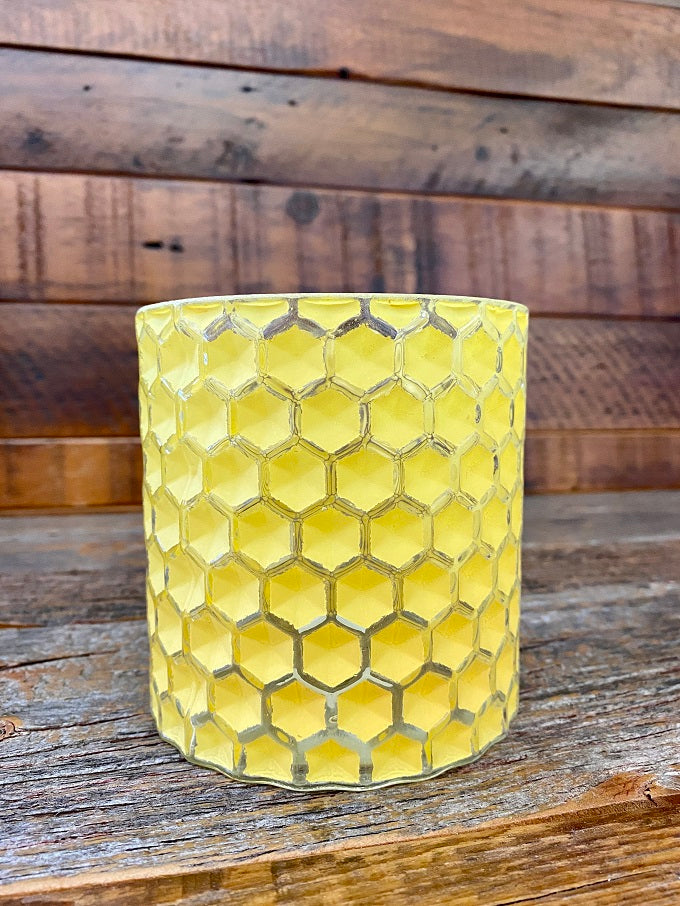 A glass yellow jar textured as honeycomb.