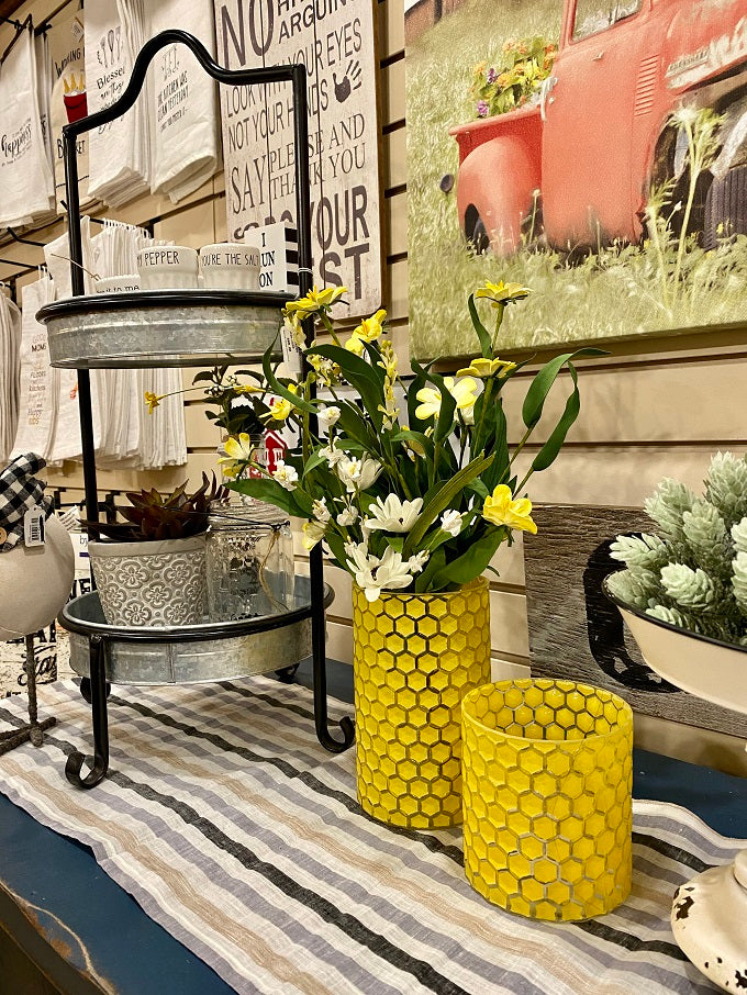 Two glass yellow honeycomb jars are shown with other farmhouse decor.