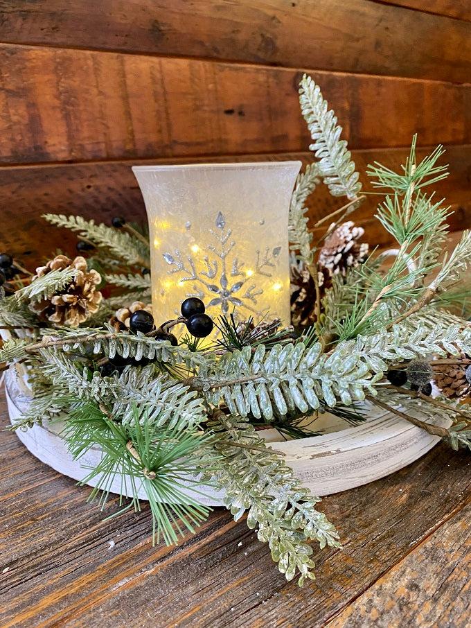 A single frosted white glass hurricane jar have a snowflake pattern in silver on the outside. 