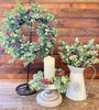 Wreath, candle ring and sprays that are a part of the Holiday Eucalyptus collection. All of the pieces are white dusted eucalyptus with red berries incorporated in them as well. 