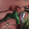 A close up of green and red faucet from the the distressed metal half buckets garden hanger. 