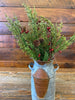 The Evergreen pine pick features feature green pine-like stems, and red berry pips and pine cones. 