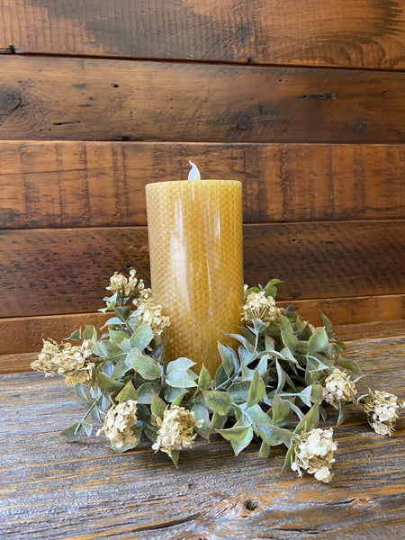 7" tall honeycomb pillar timer candle is pictured with a green candle ring around it. 