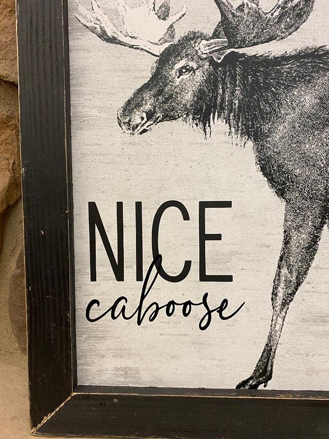 This fun picture has a moose  and the words, "Nice Caboose".  It is in a black wooden distrssed frame and measures 13" x 17". There is a vintage wire attached to the frame for easy hanging. 