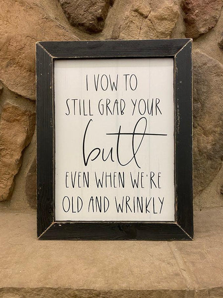 This is a picture that says: I vow to still grab your butt even when we are old and wrinkly is printed in black on a white background. It is framed in a black distressed frame. 